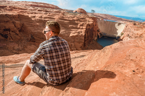 A young man admires the amazing view of Glen Canyon Dam and the Colorado River in Page, Arizona