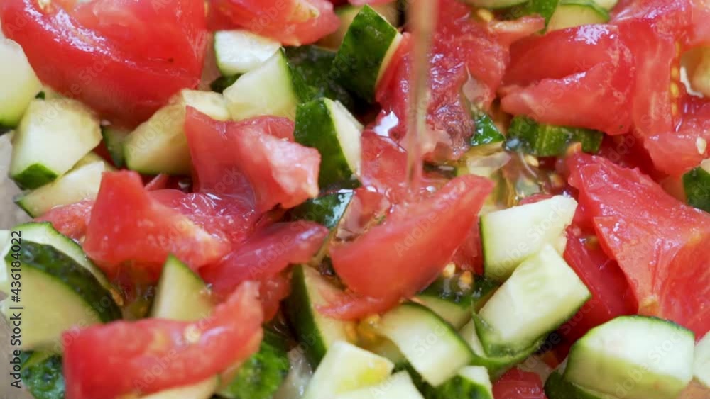 Dressing of Tomato and Cucumber Salad with Olive Oil. Olive Oil is Poured over Sliced Tomatoes and Cucumbers. Healthy Vegan Food and Diet. Dressing of Tomato and Cucumber Salad with Olive Oil. Olive Oil is Poured over Sliced Tomatoes and Cucumbers. Healthy Vegan Food and Diet.