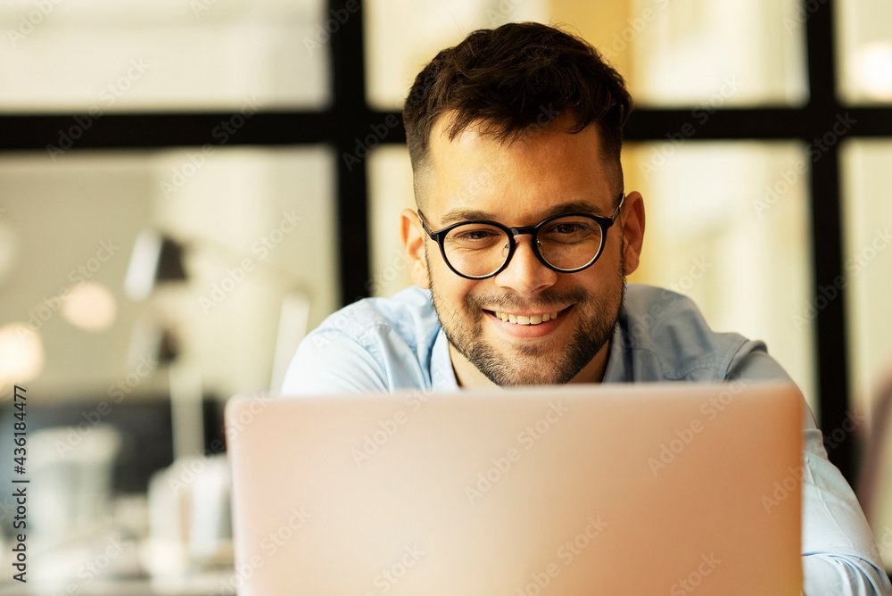 Portrait of a businessman working on laptop. Handsome man working in the office Portrait of a businessman working on laptop. Handsome man working in the office