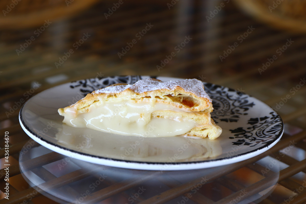 Delicious Polish cake with cream and icing sugar., called Karpatka stock photo. Custard pie with custard cream on a white background. Carpathian pie. Karpatka pie. Powder sugar on the pie.