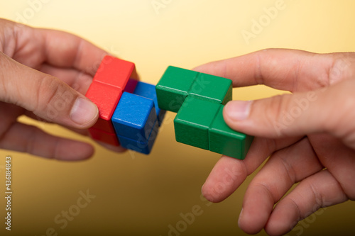 Hand holding piece of wooden block puzzle. wood cube stacking. Concept of complex and smart logical thinking. Slightly defocused and close up shot. on ... Mehr anzeigen.