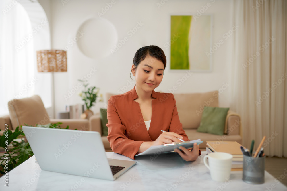 Mature successful business woman looking at mobile cell phone while at home in office work space Mature successful business woman looking at mobile cell phone while at home in office work space