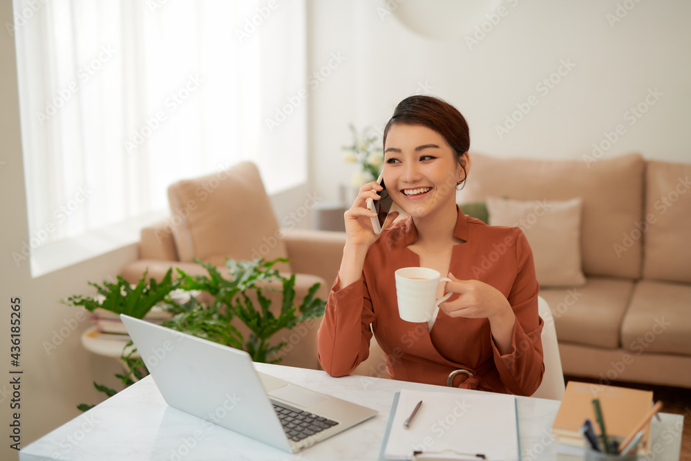 Woman using laptop and talking on mobile phone Woman using laptop and talking on mobile phone