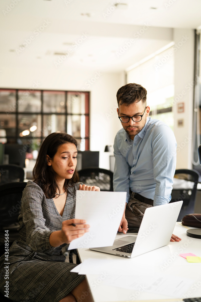 Colleagues in office. Businesswoman and businessman discussing work in office. Two friends working together