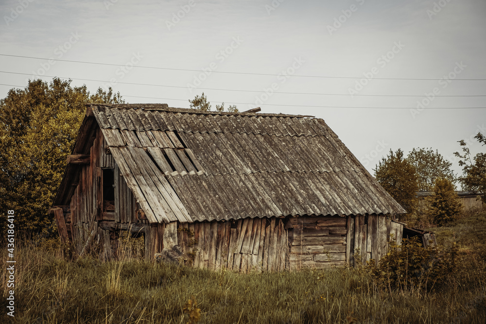 An old, abandoned log house. Deserted village in Russia. A lonely hut without people. Rotten wall construction. Hut against the background of the blue sky. Karelia. Russia. Day. An old, abandoned log house. Deserted village in Russia. A lonely hut without people. Rotten wall construction. Hut against the background of the blue sky. Karelia. Russia. Day.