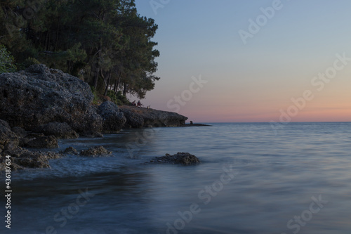 sunset on the sea near the rocky shore