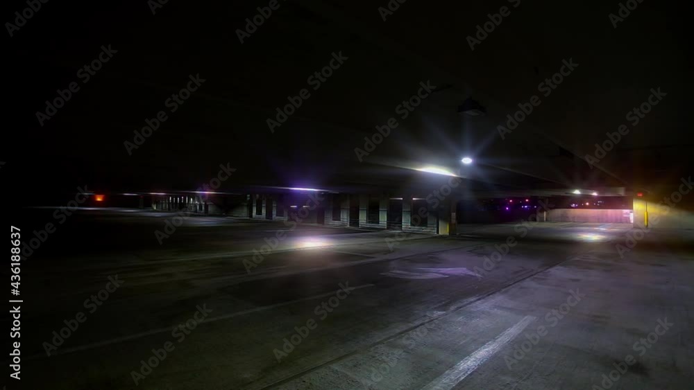 Mysterious flickering lights in late night empty parking garage. Dark