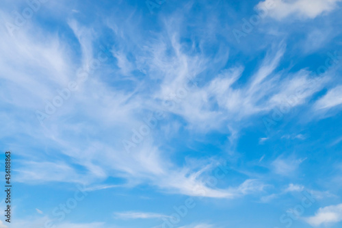 Blue sky background with cirrus white clouds, soft focus.