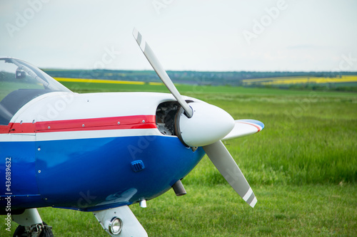 Walking small propeller plane on a green field