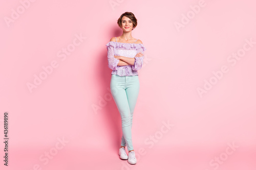 Full length photo portrait of woman with folded arms isolated on pastel pink colored background