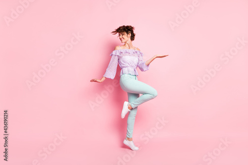 Full size photo of young happy smiling cheerful positive good mood girl dancing isolated on pink color background