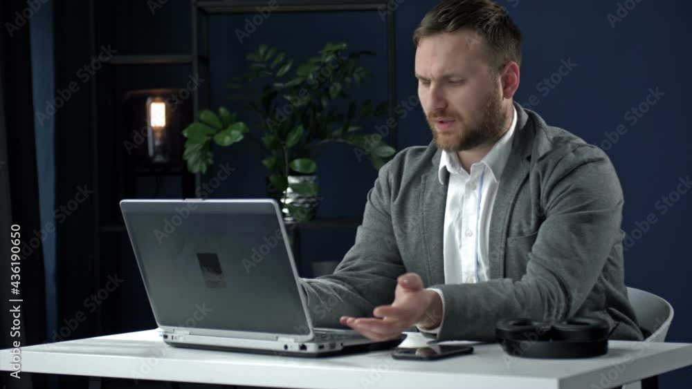 Portrait of a middle aged businessman sitting late at night in front of a laptop. The man is dissatisfied with something. Fatigue, overwork. Portrait of a middle aged businessman sitting late at night in front of a laptop. The man is dissatisfied with something. Fatigue, overwork.