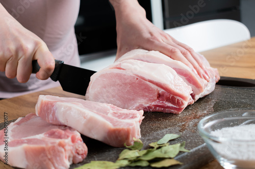 Chef cuts a meat in chopping board