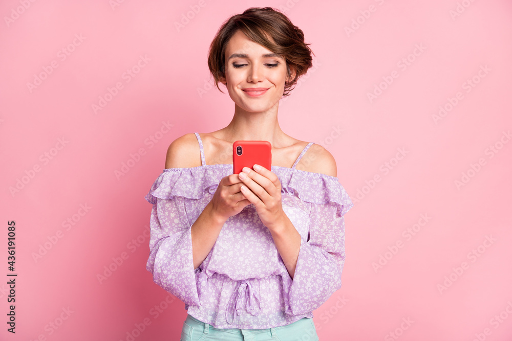 Photo of young beautiful charming happy positive girl blogger addicted to smartphone isolated on pink color background Photo of young beautiful charming happy positive girl blogger addicted to smartphone isolated on pink color background