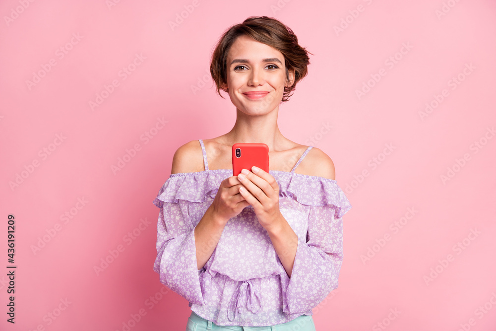 Photo of young beautiful happy cheerful positive girl using phone browse in social network isolated on pink color background Photo of young beautiful happy cheerful positive girl using phone browse in social network isolated on pink color background