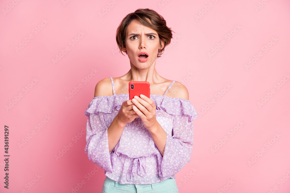 Photo of young shocked amazed surprised girl blogger see dislike in social network isolated on pink color background Photo of young shocked amazed surprised girl blogger see dislike in social network isolated on pink color background