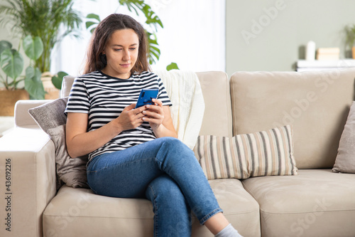 Young woman using phone at home