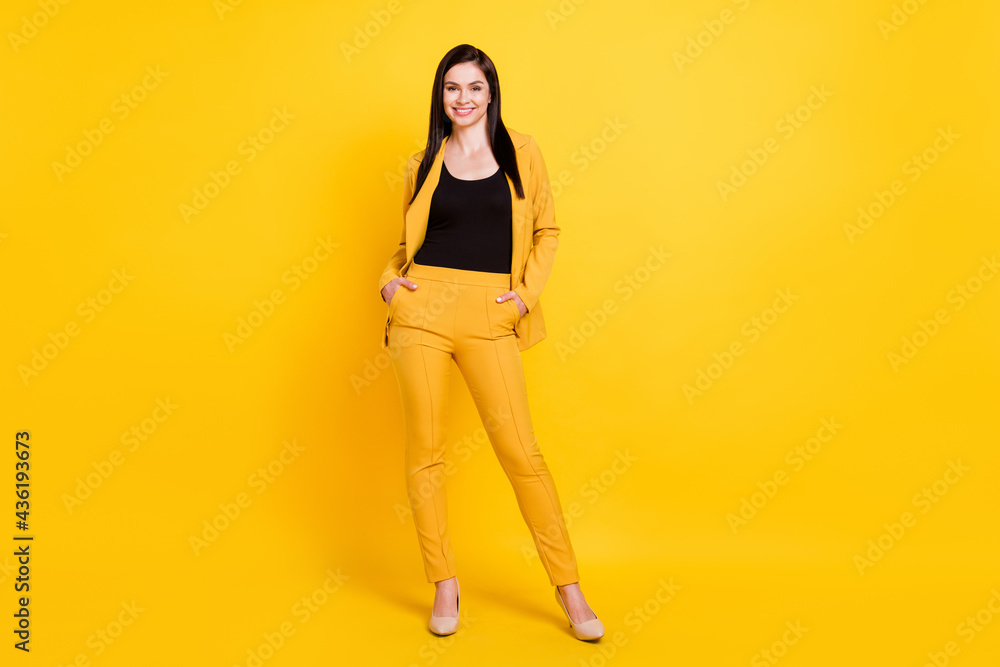 Photo of sweet pretty young woman wear formal jacket arms pockets smiling isolated yellow color background Photo of sweet pretty young woman wear formal jacket arms pockets smiling isolated yellow color background