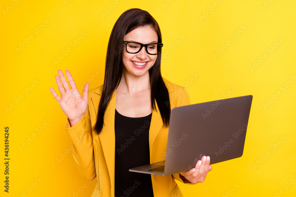 Photo of young woman happy positive smile conference video call meeting online computer isolated over yellow color background Photo of young woman happy positive smile conference video call meeting online computer isolated over yellow color background