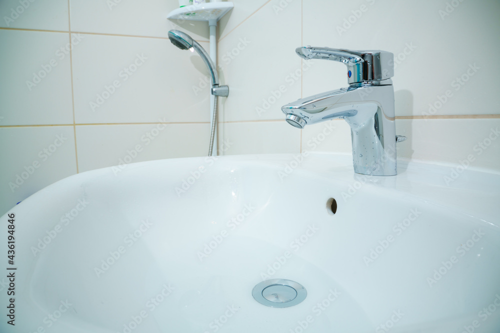 chromed metal faucet for hot and cold water in a modern bathroom chromed metal faucet for hot and cold water in a modern bathroom