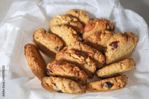 Stack of crispy oat cookies with cranberry raisins on white background or on baking sheet