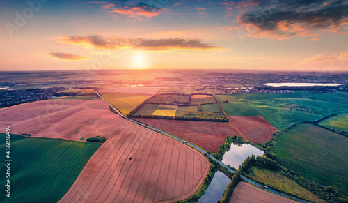 Aerial landscape photography. Exciting summer sunrise on Ternopil outskirts with smal lake and asphalt road. Colorful morning view of hte Ukrainian countryside. photo