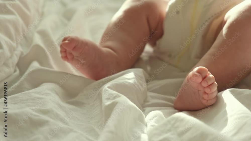 Tiny Human Feet of Caucasian Neonate Toddler is in Focus. Authentic Close Up Footage of Newborn Baby Lying on the Back. Concept of Childhood, New Llife and Maternity. Baby feet in mother's hands. Tiny Human Feet of Caucasian Neonate Toddler is in Focus. Authentic Close Up Footage of Newborn Baby Lying on the Back. Concept of Childhood, New Llife and Maternity. Baby feet in mother's hands.