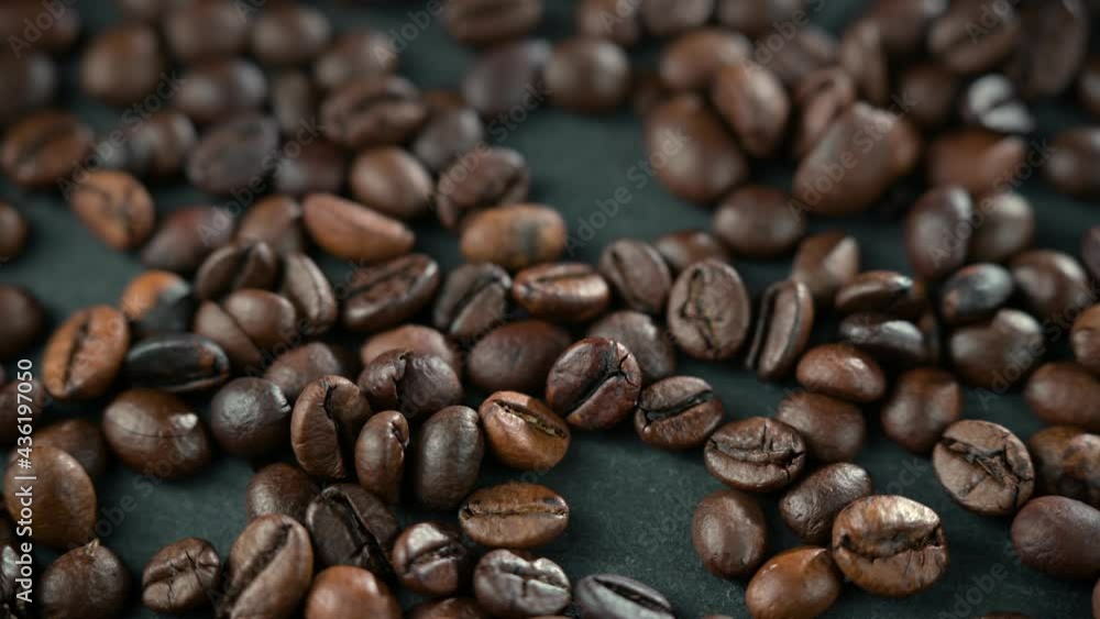 Video slow motion of seeds of coffee. Coffee beans are scattered on the table. Background in blur. Video slow motion of seeds of coffee. Coffee beans are scattered on the table. Background in blur.