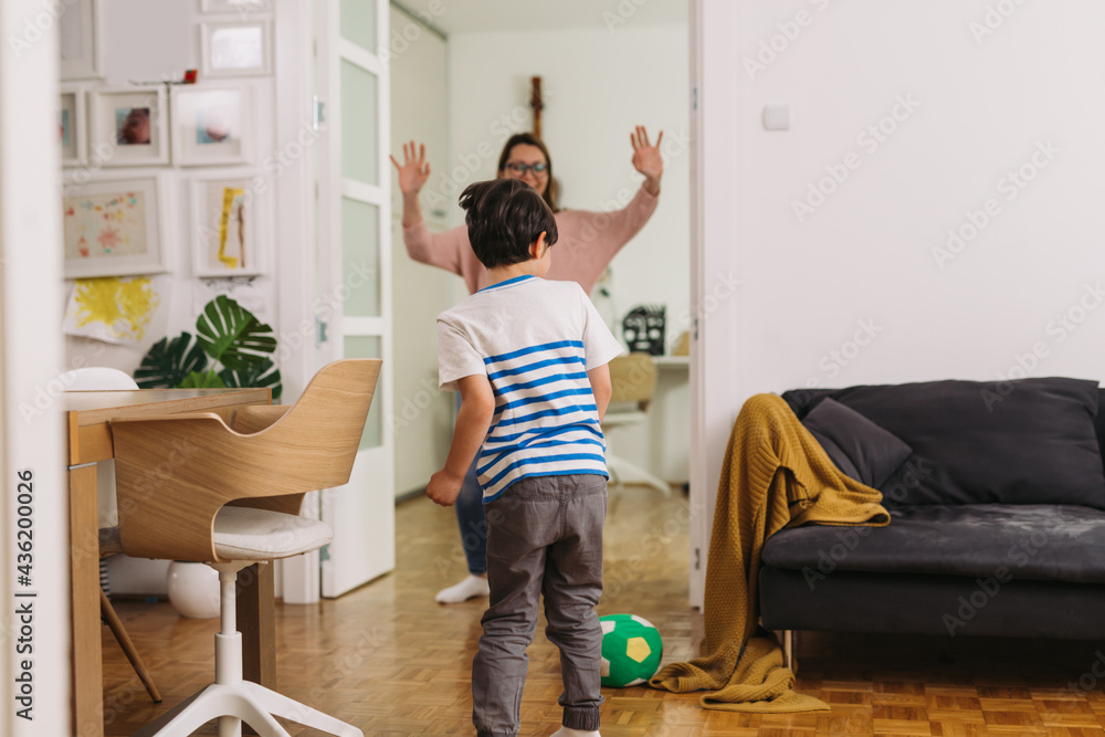 mother playing soccer with her son at home