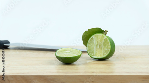 Cutting limes with leaf on Wooden cutting board