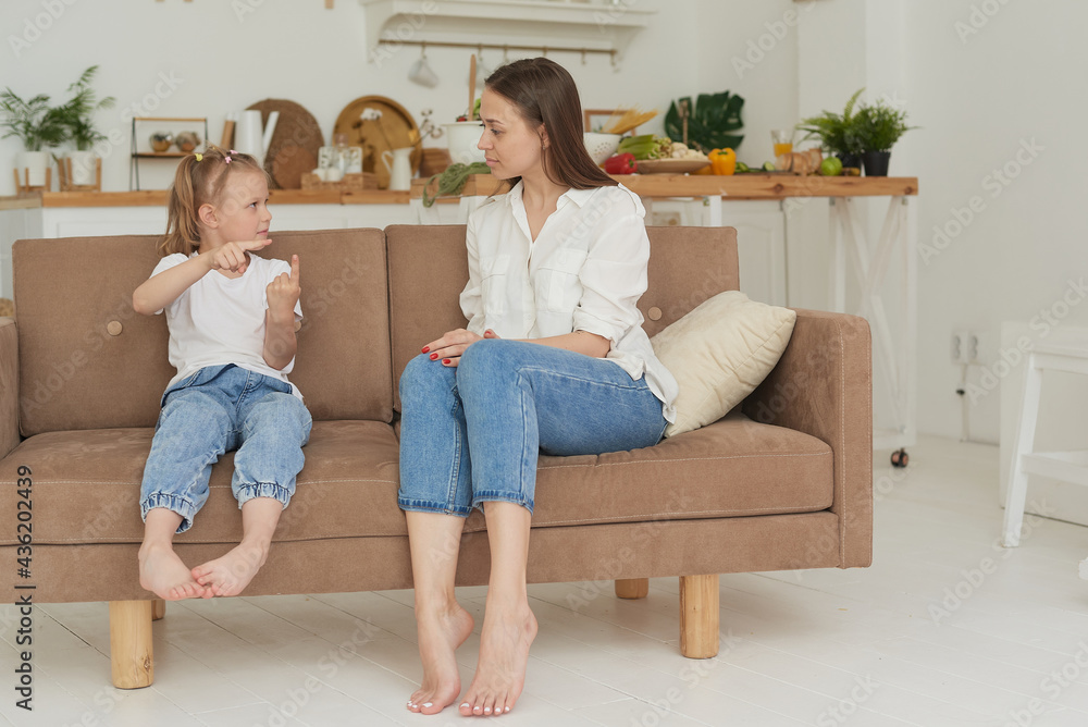 A young mother is talking heart to heart with her child. The psychologist communicates with a little girl at home A young mother is talking heart to heart with her child. The psychologist communicates with a little girl at home
