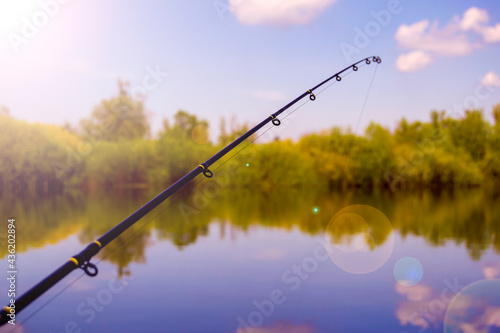Fotografia fishing rod with rings on the background of blue sky and river