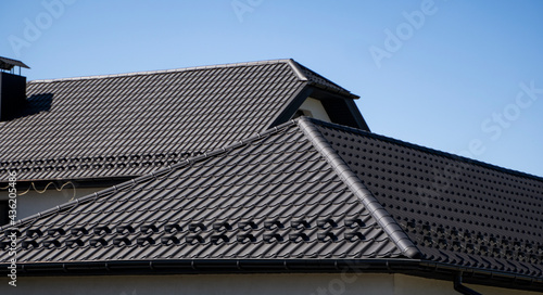 Brown corrugated metal profile roof installed on a modern house. The roof of corrugated sheet. Roofing of metal profile wavy shape. Modern roof made of metal. Metal roofing.
