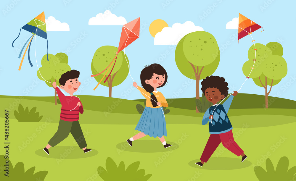 Three happy smiling diverse little children are playing with kites outdoors in a park
