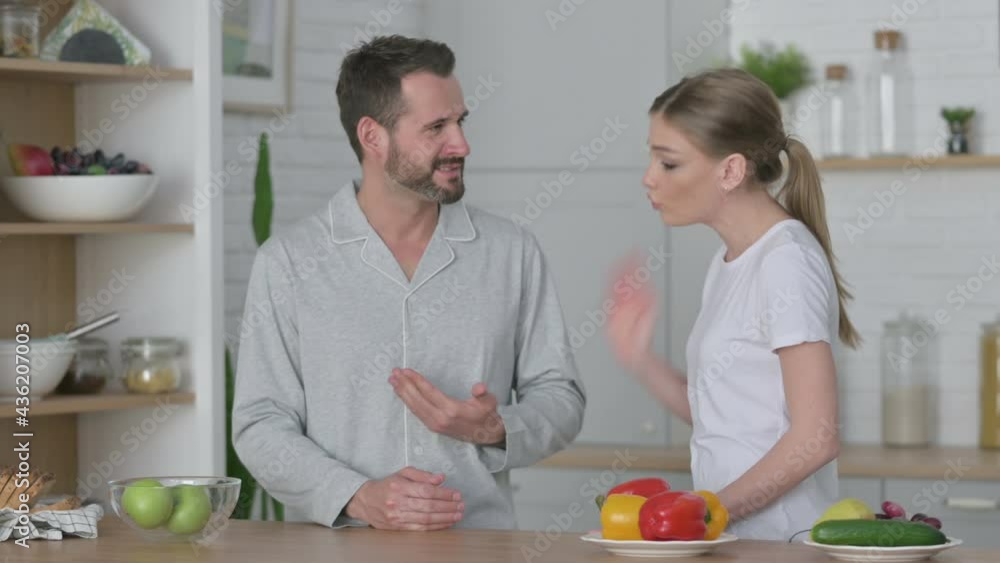 Young Woman Arguing with Man in Kitchen Young Woman Arguing with Man in Kitchen