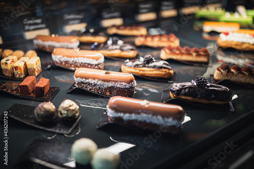 delicious assorted eclairs and sweets on a black table