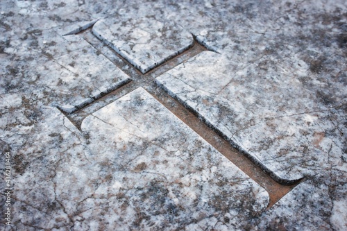 Obraz na plátně Christian cross emblem engraved in marble tombstone in a graveyard