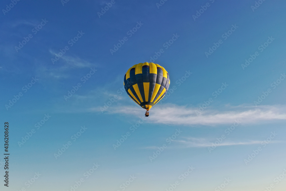 Naklejka premium Hot air balloon in flight at sunset. View from the drone.