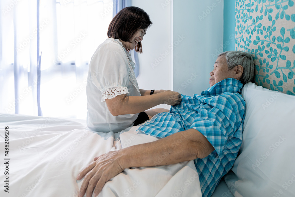 Assisting in dressing,female caregiver taking care of helping elderly