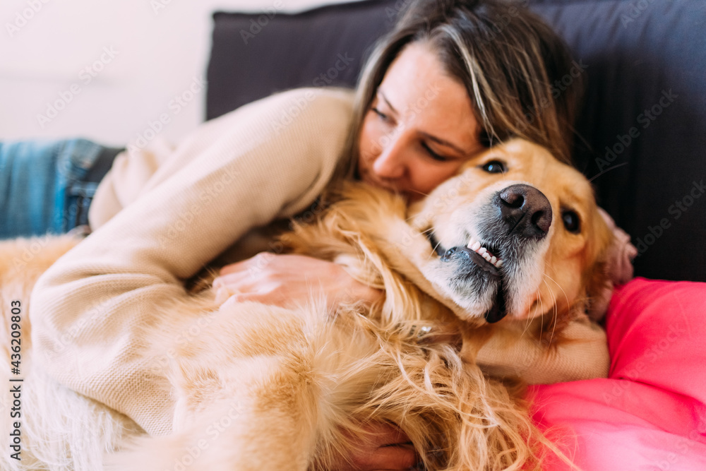 Young woman and dog relaxing on bed Young woman and dog relaxing on bed