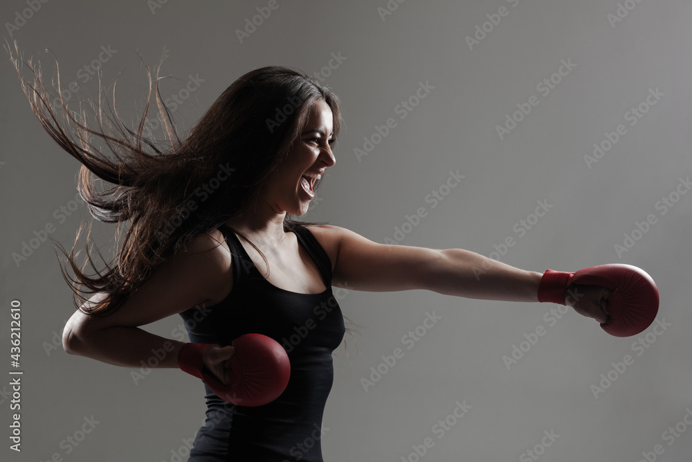 girl exercising karate punch and screaming against gray background girl exercising karate punch and screaming against gray background