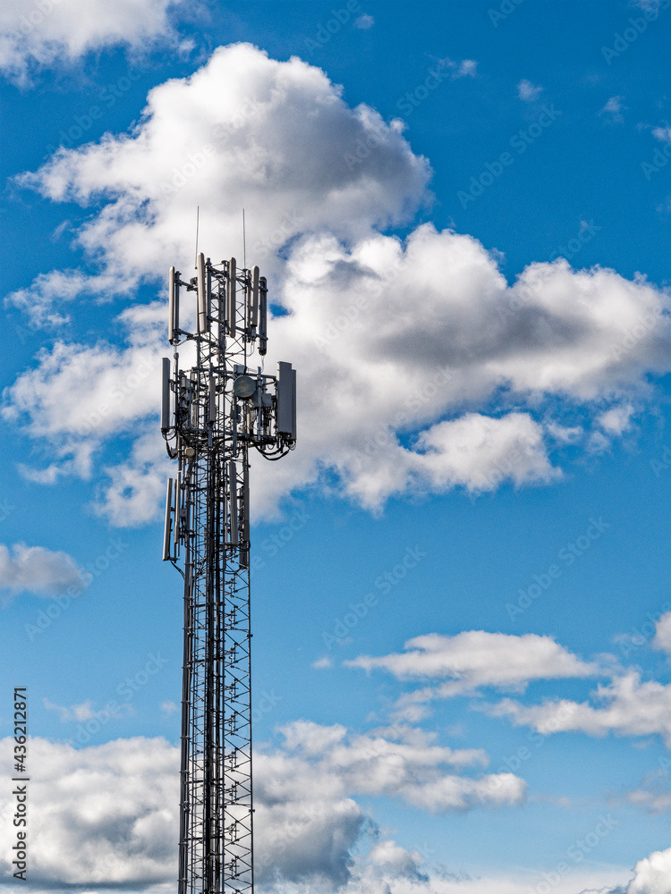 Mobile phone mast against a blue sky with clouds Mobile phone mast against a blue sky with clouds