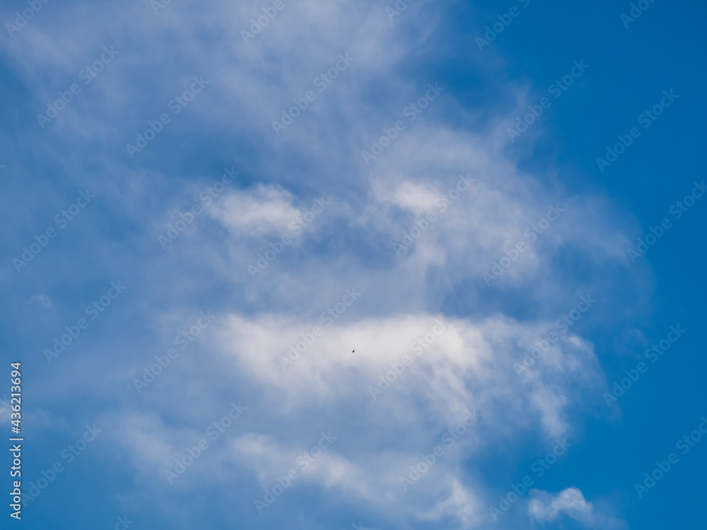 Unusual white clouds in form of evil face in blue sky