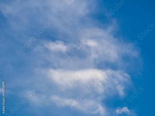 Unusual white clouds in form of evil face in blue sky