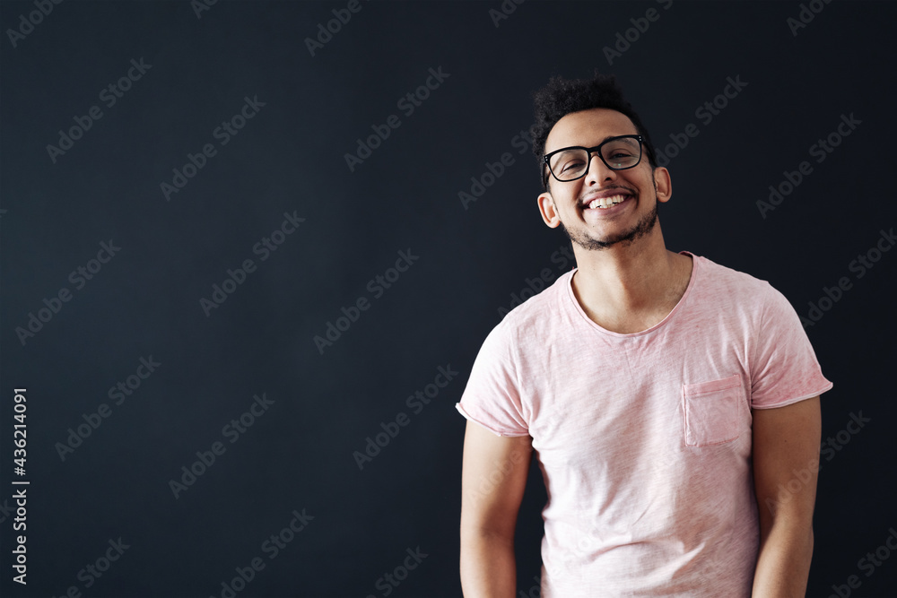 Young handsome man with beard wearing casual t shirt and glasses over black background face smiling looking at the camera with copy space. Positive person. Young handsome man with beard wearing casual t shirt and glasses over black background face smiling looking at the camera with copy space. Positive person.