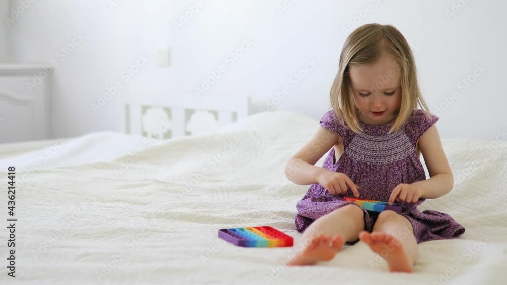 Adorable little girl playing with pop it fidget Adorable little girl playing with pop it fidget