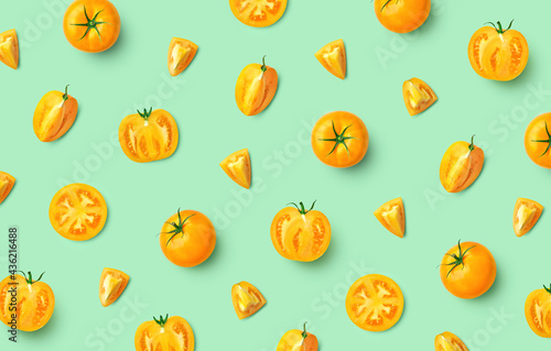 Colorful pattern of fresh whole and sliced yellow tomatoes
