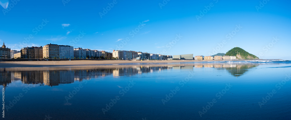 Fototapeta premium La ciudad de Donostia-San Sebastian se refleja en la playa de la zurriola, Euskadi