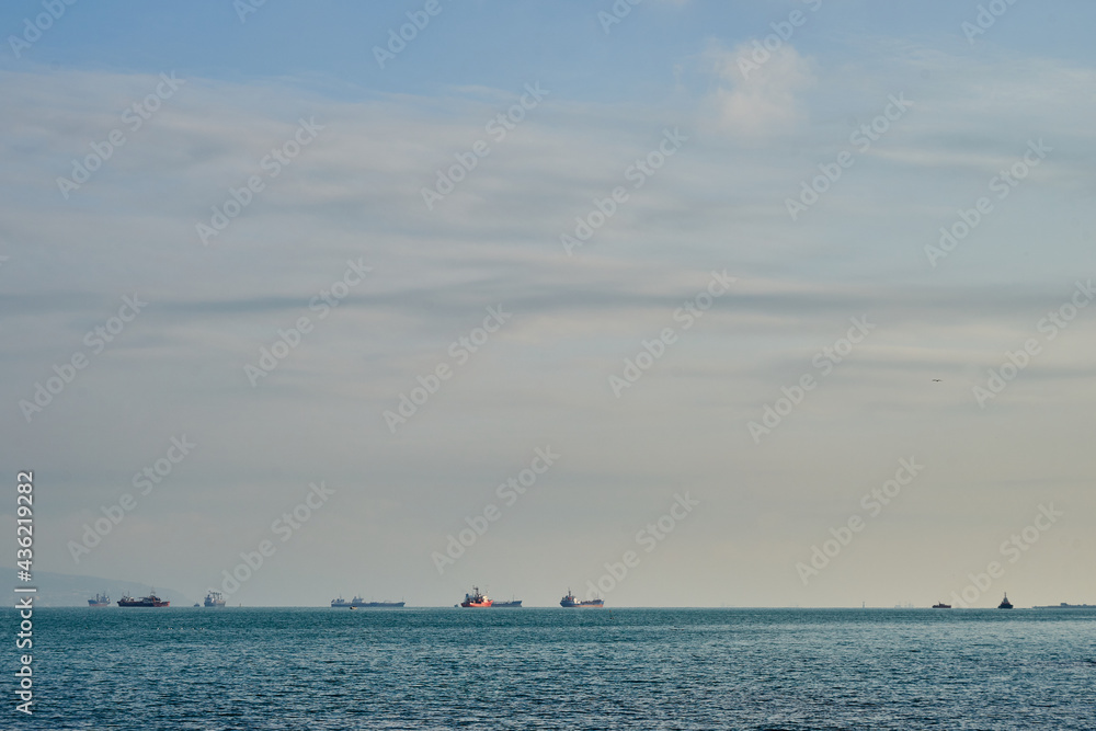 Image of merchant ships in the sea at anchorage.