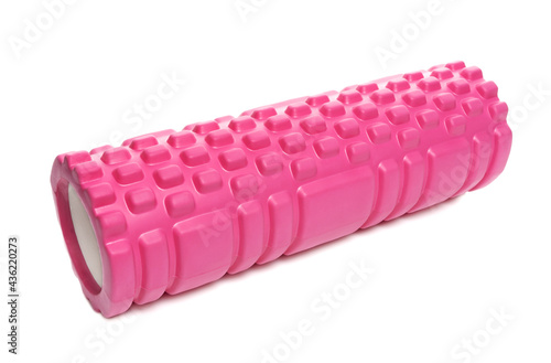 Pink massage roller made of lumpy foam. Foam rolling is a myofascial relaxation technique used by athletes and physical therapists to suppress overactive muscles photo
